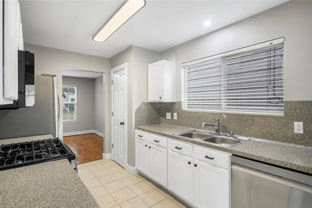 a kitchen with granite countertop a sink a stove and cabinets
