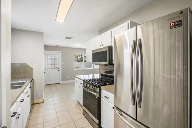 a kitchen with stainless steel appliances granite countertop a refrigerator and a stove top oven