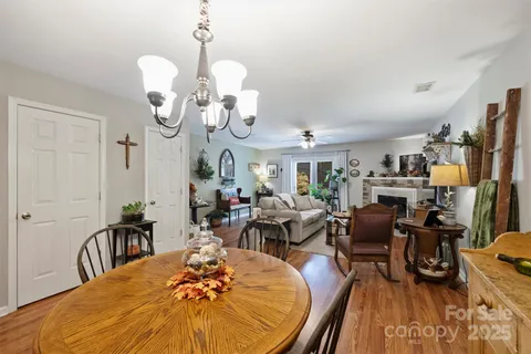 a view of a dining room with furniture a kitchen and chandelier