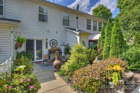 a front view of a house with a yard and potted plants