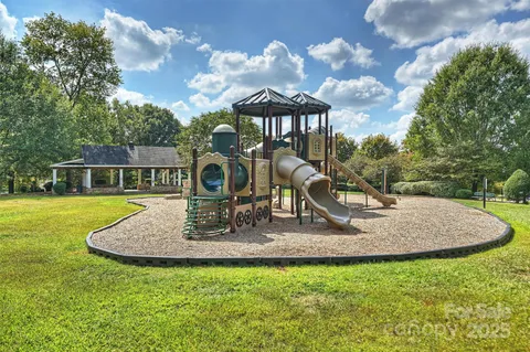 a view of a house with backyard fountain and sitting area