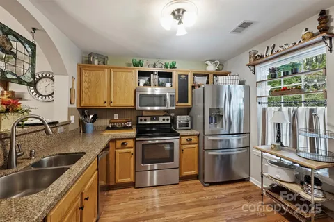 a kitchen with stainless steel appliances granite countertop a refrigerator and a sink