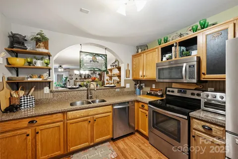 a kitchen with stainless steel appliances a stove sink and microwave