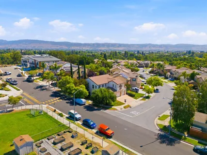 an aerial view of a city with lots of residential buildings ocean and mountain view in back
