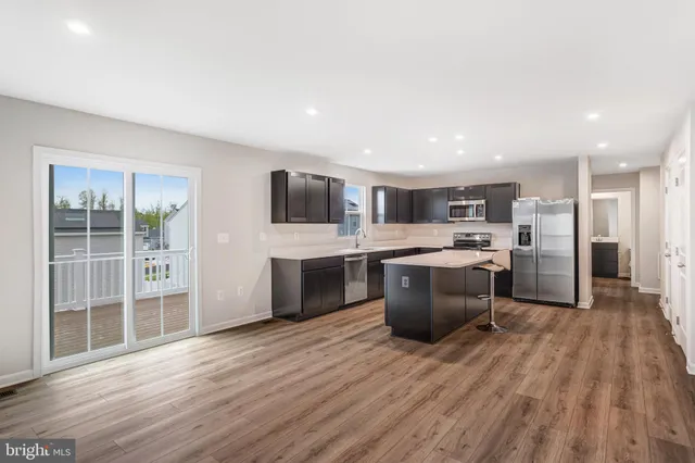 a large kitchen with a center island and stainless steel appliances