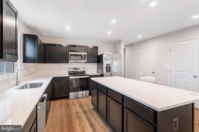 a kitchen with stainless steel appliances a sink stove refrigerator and cabinets
