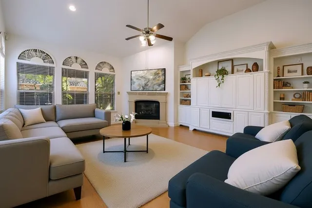 a living room with furniture fireplace and a large window