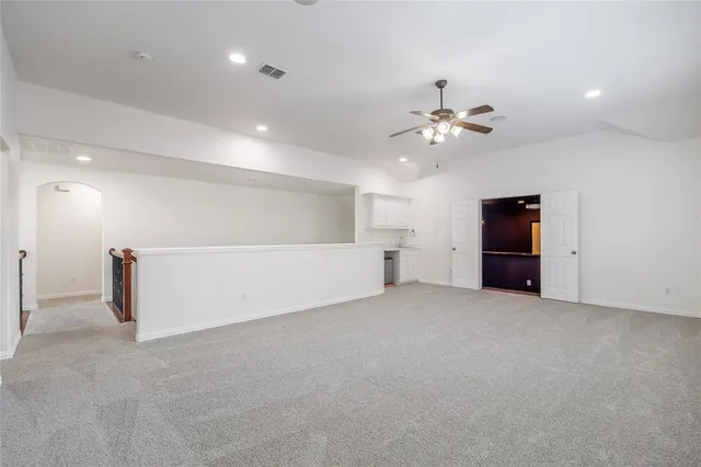 an empty room with closet and a ceiling fan