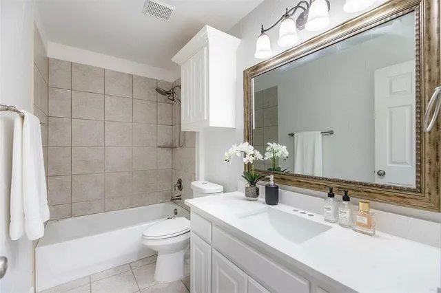 a bathroom with a toilet a sink a mirror a bathtub and shower