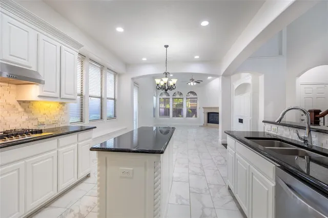 a kitchen with granite countertop a sink stainless steel appliances and cabinets