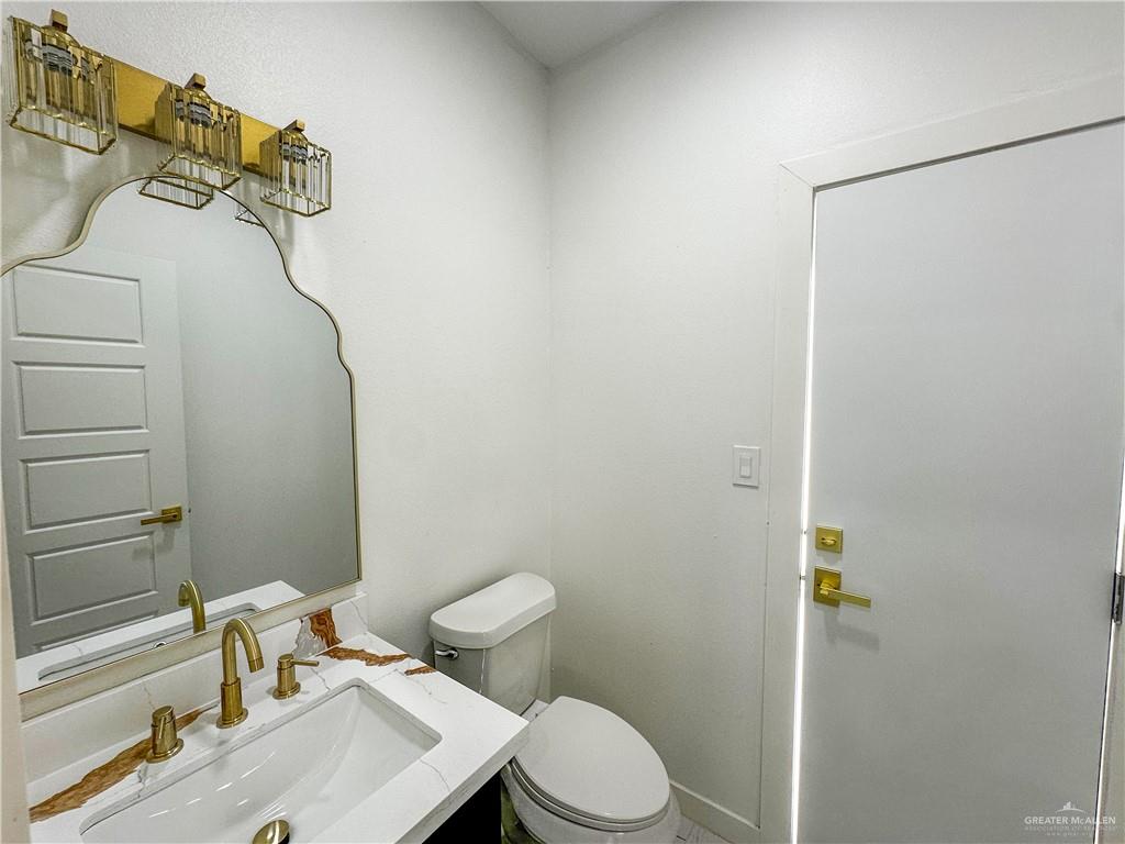 909 Azalea Street Mission, TX 78573 - Photo 23 of 29 1/2 bathroom with exit to the backyard