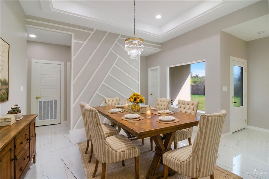 909 Azalea Street Mission, TX 78573 - Photo 6 of 29 Dining area featuring a tray ceiling and hanging lights. Picture virtually staged