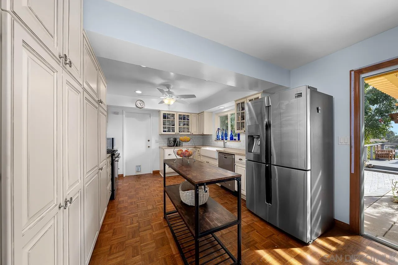 1410 Crestridge Drive Oceanside, CA 92054 - Photo 11 of 71 a kitchen with stainless steel appliances refrigerator dining table and chairs