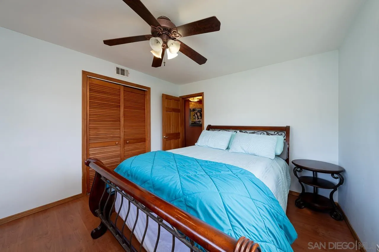 1410 Crestridge Drive Oceanside, CA 92054 - Photo 25 of 71 a bedroom with a bed and a chandelier