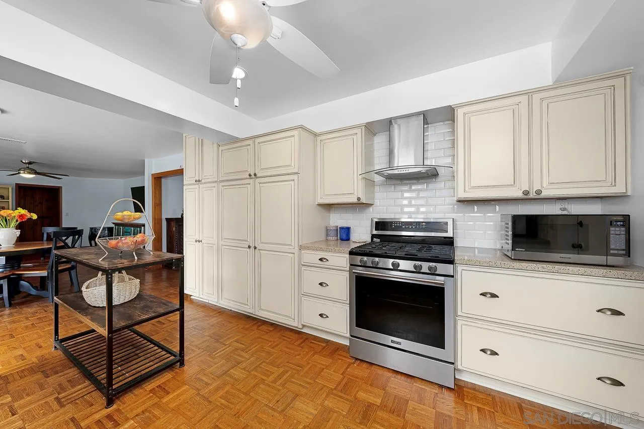 1410 Crestridge Drive Oceanside, CA 92054 - Photo 8 of 71 a kitchen with stainless steel appliances granite countertop a stove a refrigerator and a white cabinets