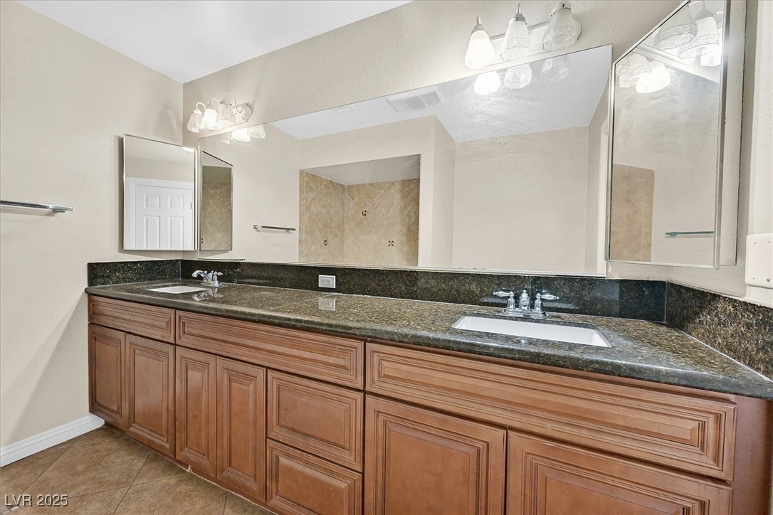 6384 West Desert Inn Road Las Vegas, NV 89146 - Photo 12 of 26 Bathroom featuring light tile patterned floors and double vanity