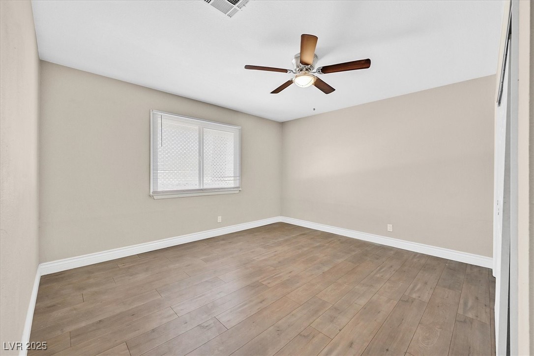 6384 West Desert Inn Road Las Vegas, NV 89146 - Photo 13 of 26 Empty room featuring light wood-style floors and a ceiling fan