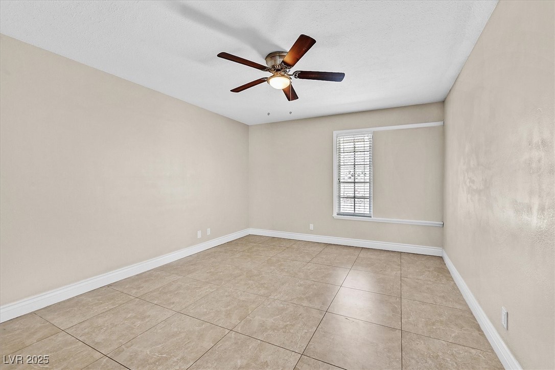 6384 West Desert Inn Road Las Vegas, NV 89146 - Photo 15 of 26 Empty room with light tile patterned flooring, a textured ceiling, and ceiling fan