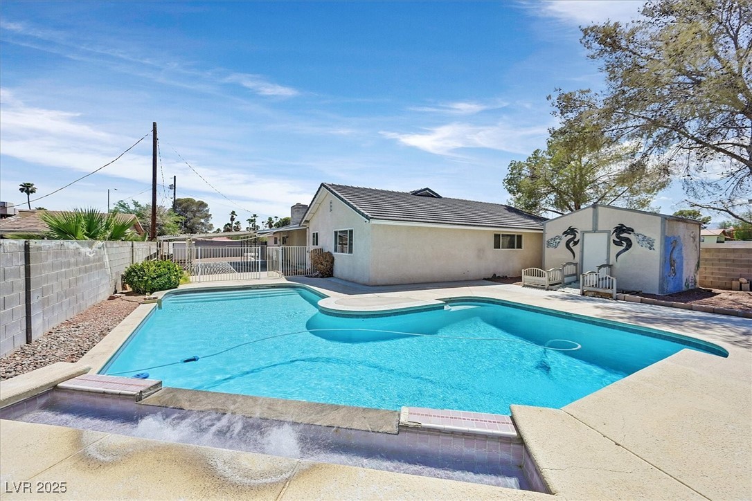 6384 West Desert Inn Road Las Vegas, NV 89146 - Photo 22 of 26 View of swimming pool featuring a fenced backyard, a patio area, and an outbuilding