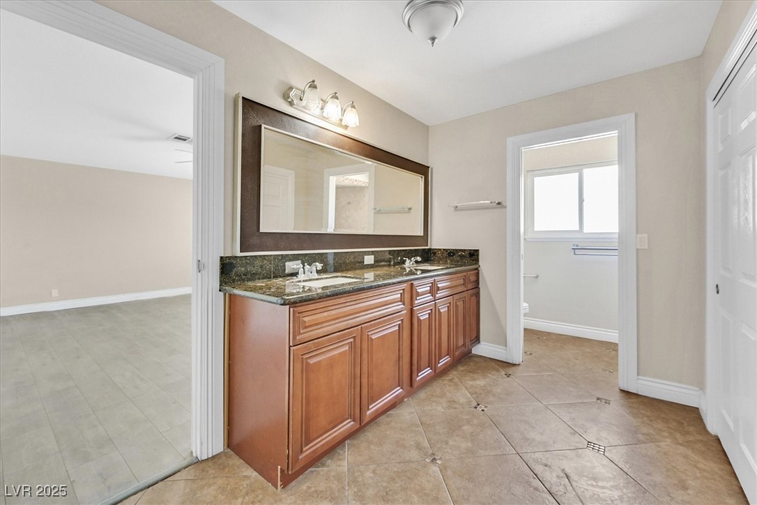 6384 West Desert Inn Road Las Vegas, NV 89146 - Photo 9 of 26 Full bathroom featuring double vanity and light tile patterned floors