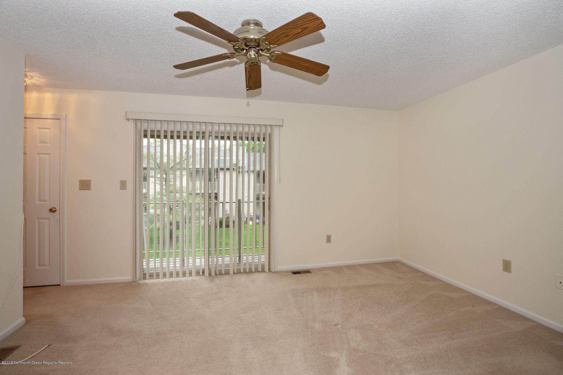 16 Stuart Drive, Unit 8 Freehold, NJ 07728 - Photo 12 of 28 an empty room with a ceiling fan and window