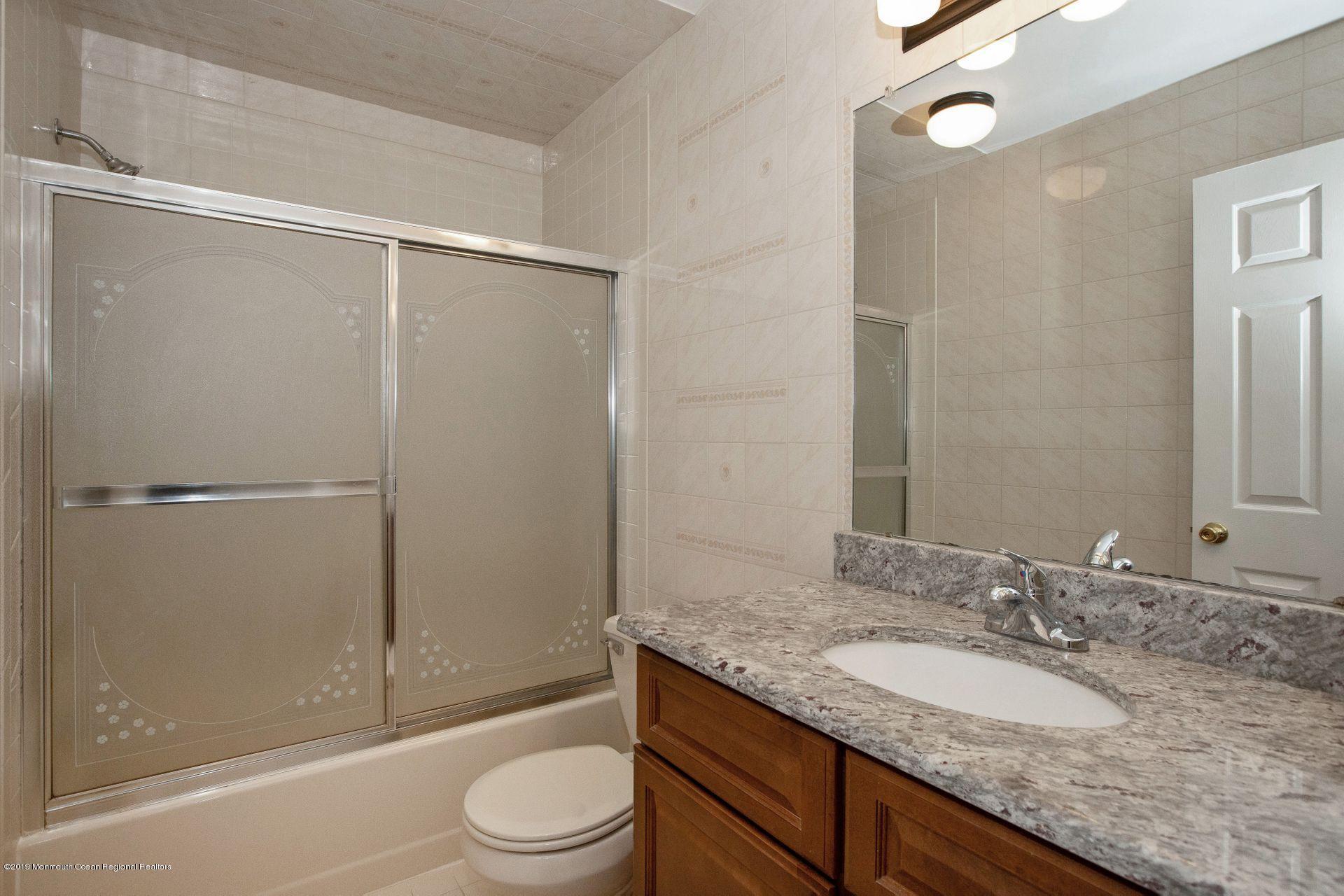16 Stuart Drive, Unit 8 Freehold, NJ 07728 - Photo 13 of 28 a bathroom with a granite countertop sink toilet and shower