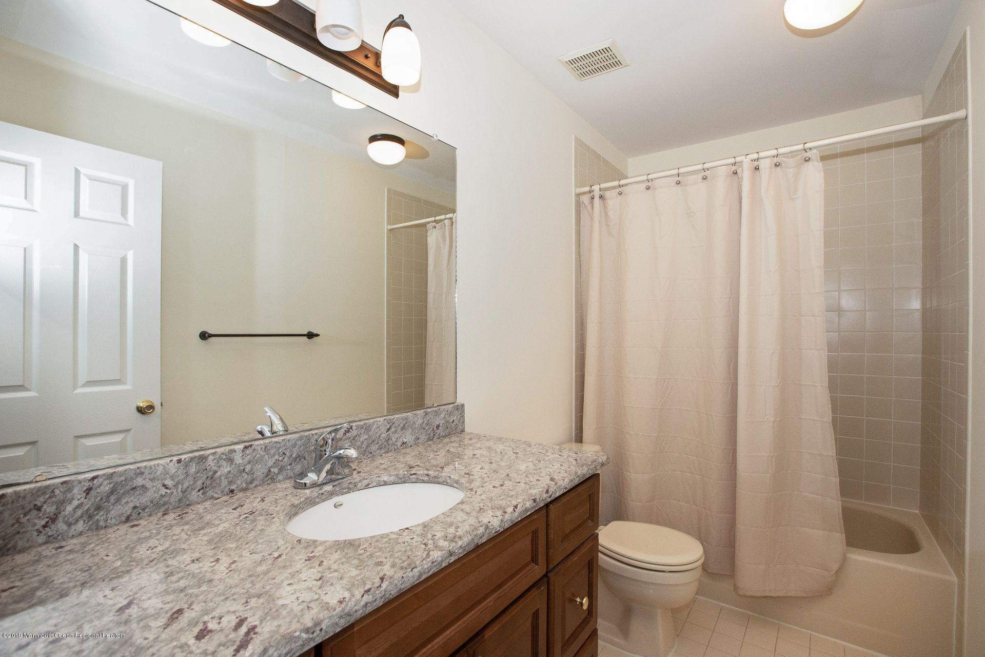 16 Stuart Drive, Unit 8 Freehold, NJ 07728 - Photo 15 of 28 a bathroom with a granite countertop sink toilet and a mirror