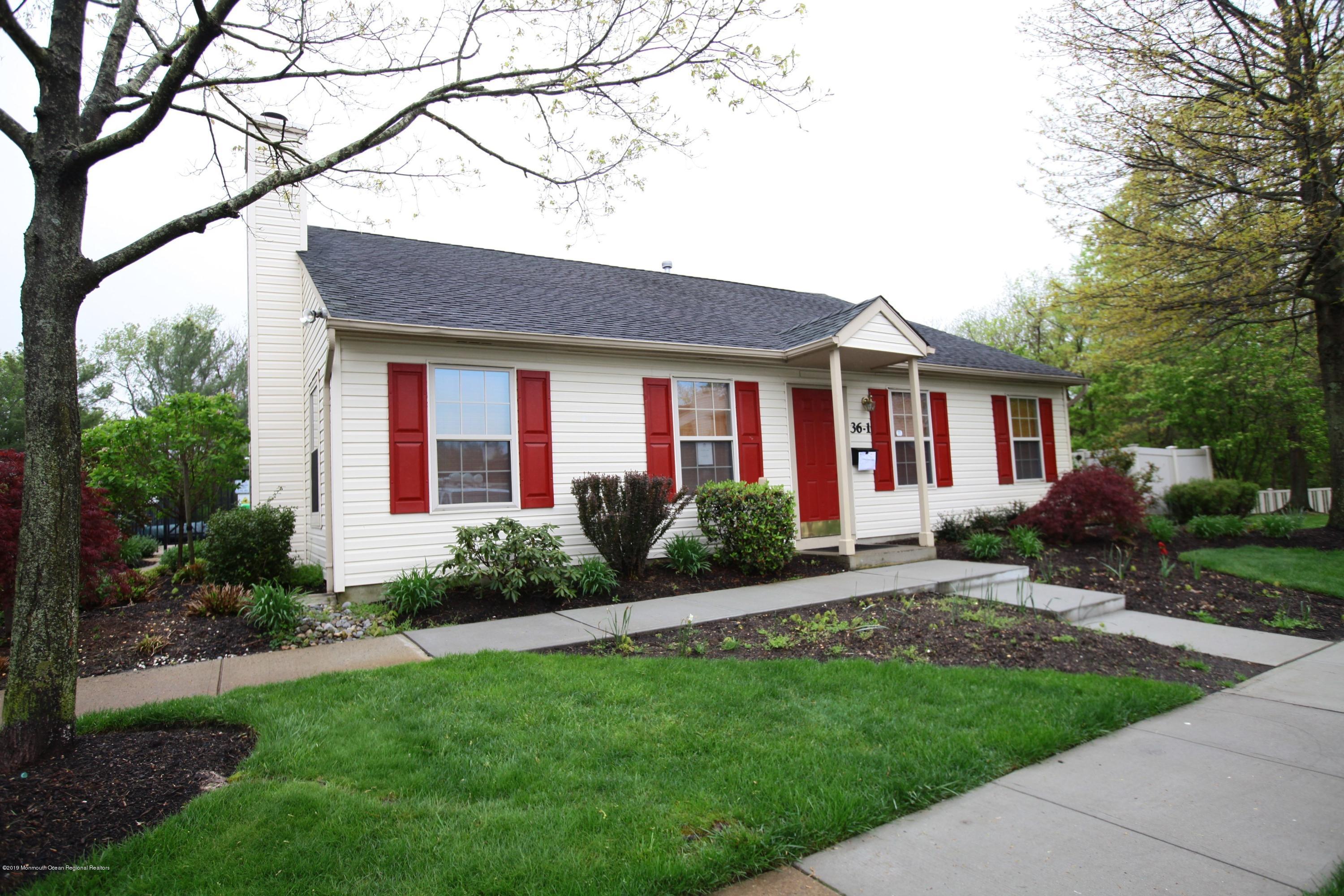 16 Stuart Drive, Unit 8 Freehold, NJ 07728 - Photo 26 of 28 a front view of a house with a garden and yard