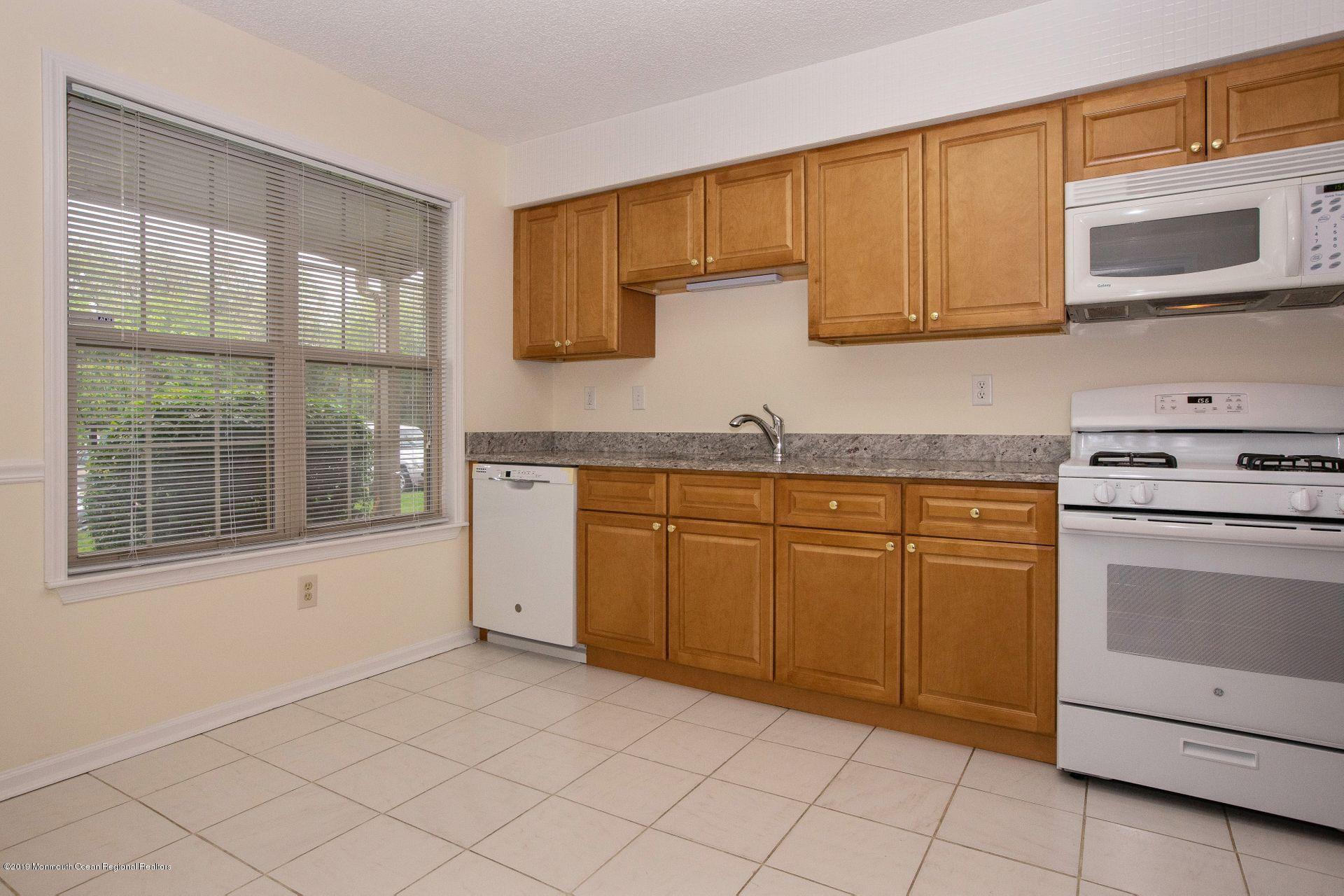 16 Stuart Drive, Unit 8 Freehold, NJ 07728 - Photo 5 of 28 a kitchen with granite countertop cabinets stainless steel appliances and a sink
