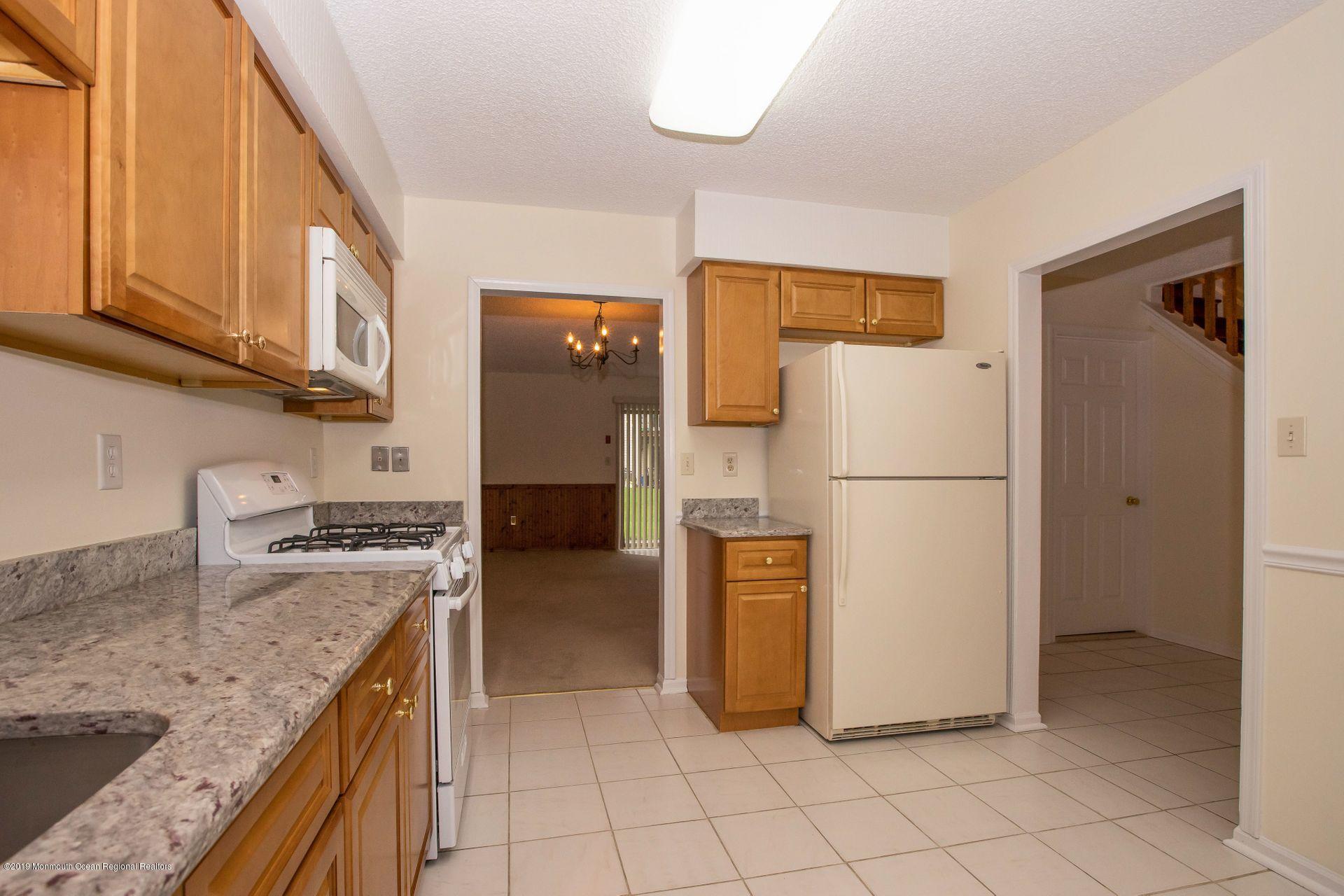 16 Stuart Drive, Unit 8 Freehold, NJ 07728 - Photo 6 of 28 a kitchen with granite countertop a refrigerator and a stove