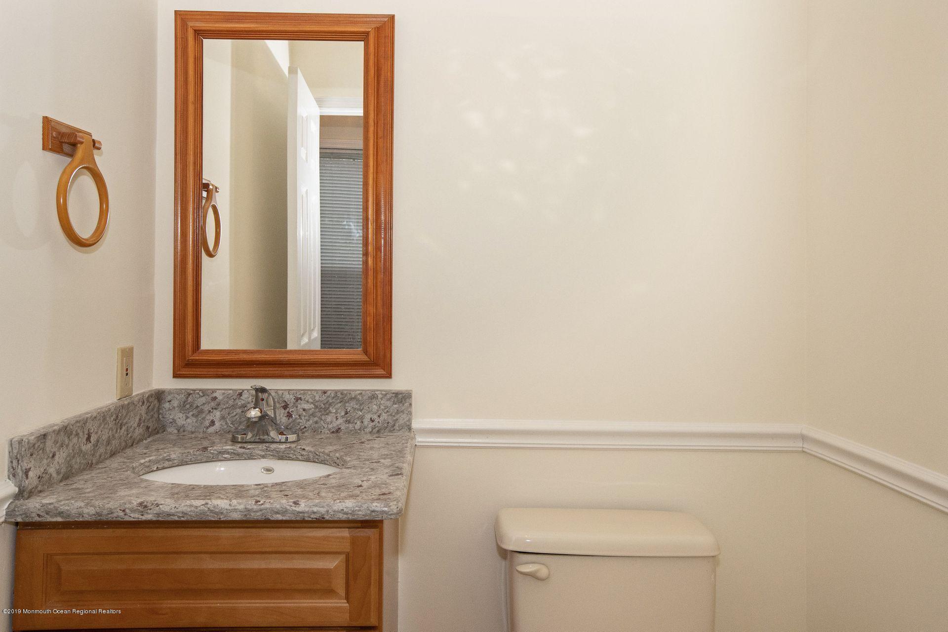 16 Stuart Drive, Unit 8 Freehold, NJ 07728 - Photo 10 of 28 a bathroom with a granite countertop sink and a mirror
