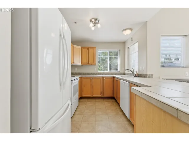 a large white kitchen with a sink and a large window