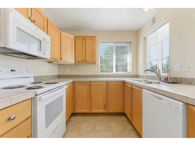 a kitchen with granite countertop a sink stainless steel appliances and cabinets