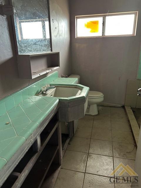 Undisclosed Address Bakersfield, CA 93305 - Photo 9 of 16 a bathroom with a sink a toilet and a window