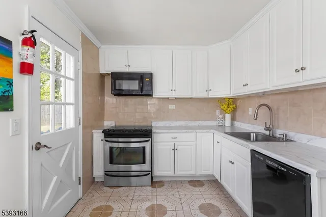 a kitchen with granite countertop white cabinets stainless steel appliances and sink