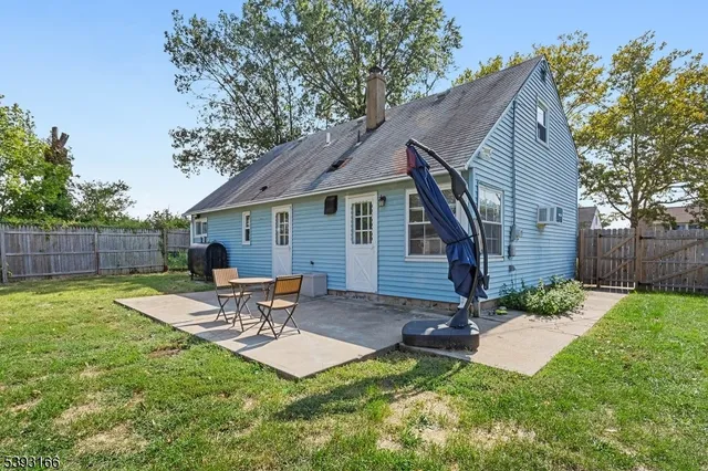 a view of a backyard with table and chairs potted plants and wooden fence