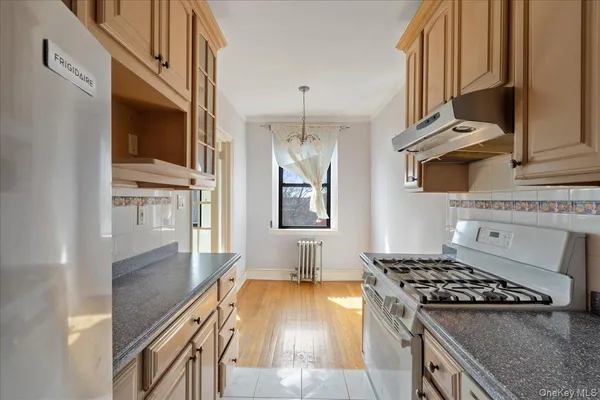 a kitchen with granite countertop stainless steel appliances stove top oven and cabinets