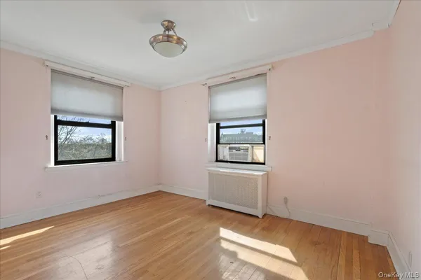 a view of an empty room with closet and a window