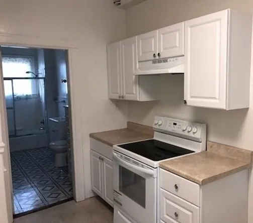 a kitchen with granite countertop white cabinets and white appliances