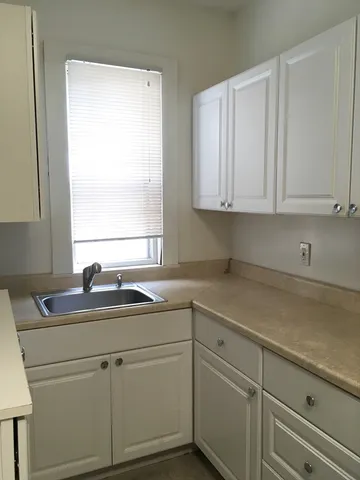 a kitchen with a sink cabinets and window