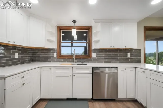 a kitchen with white cabinets and sink