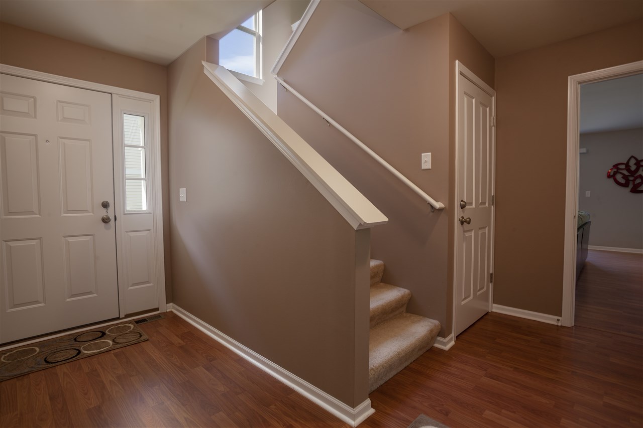 7634 Jockey Drive Loves Park, IL 61111 - Photo 2 of 25 a view of entryway with stairs and wooden floor