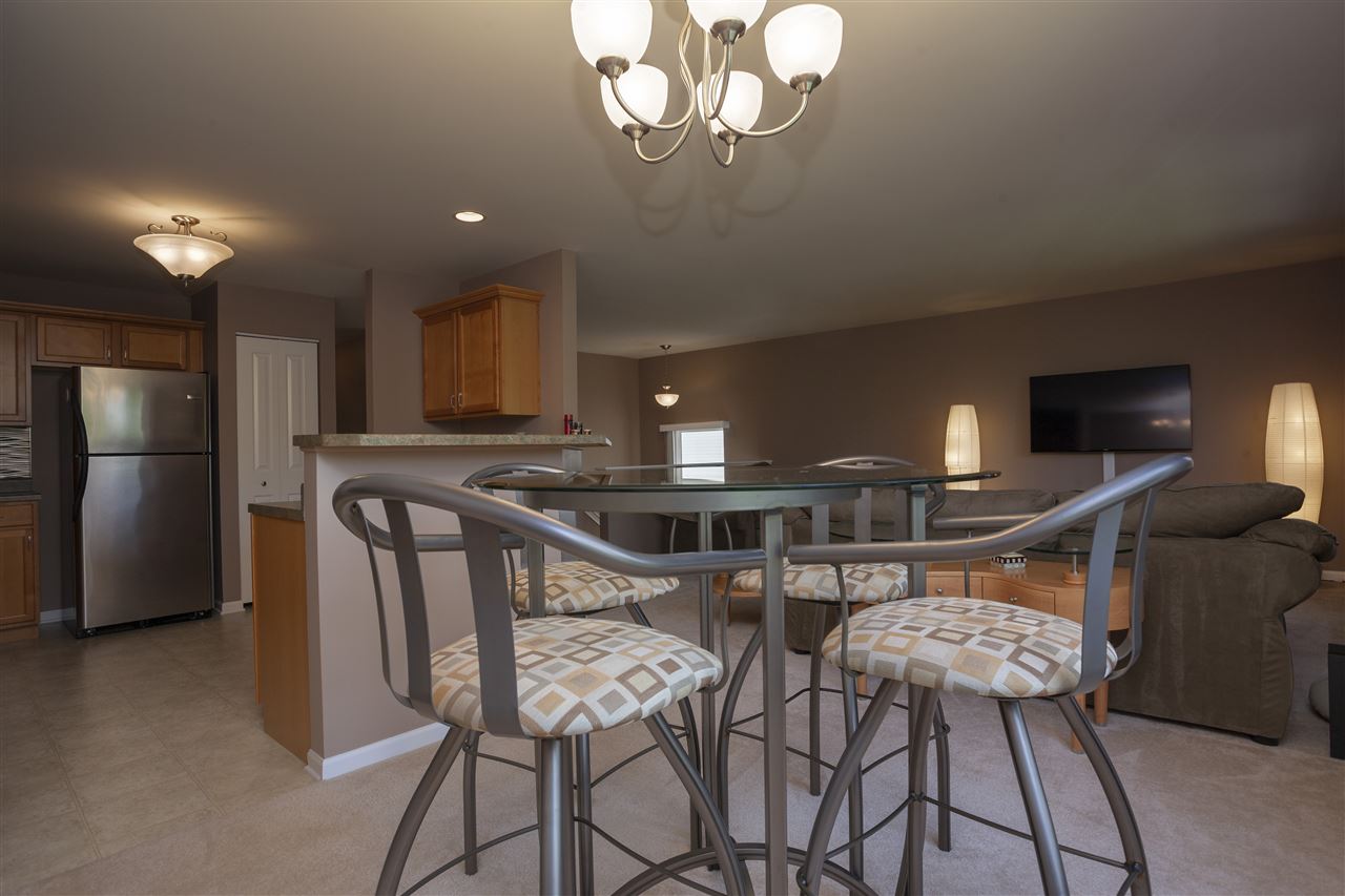 7634 Jockey Drive Loves Park, IL 61111 - Photo 6 of 25 a kitchen with stainless steel appliances granite countertop a dining table chairs and a refrigerator