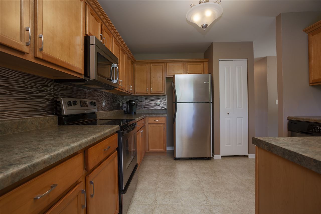 7634 Jockey Drive Loves Park, IL 61111 - Photo 7 of 25 a kitchen with stainless steel appliances granite countertop a refrigerator a stove a sink and a microwave