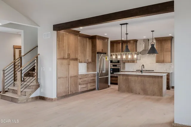 a kitchen with stainless steel appliances granite countertop a refrigerator and a sink