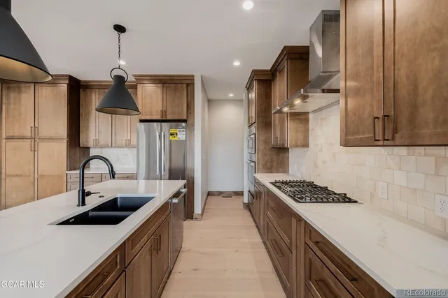 a kitchen with stainless steel appliances a sink stove and refrigerator
