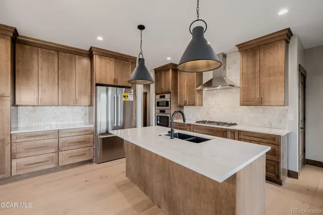 a kitchen with stainless steel appliances granite countertop a stove a sink and a refrigerator