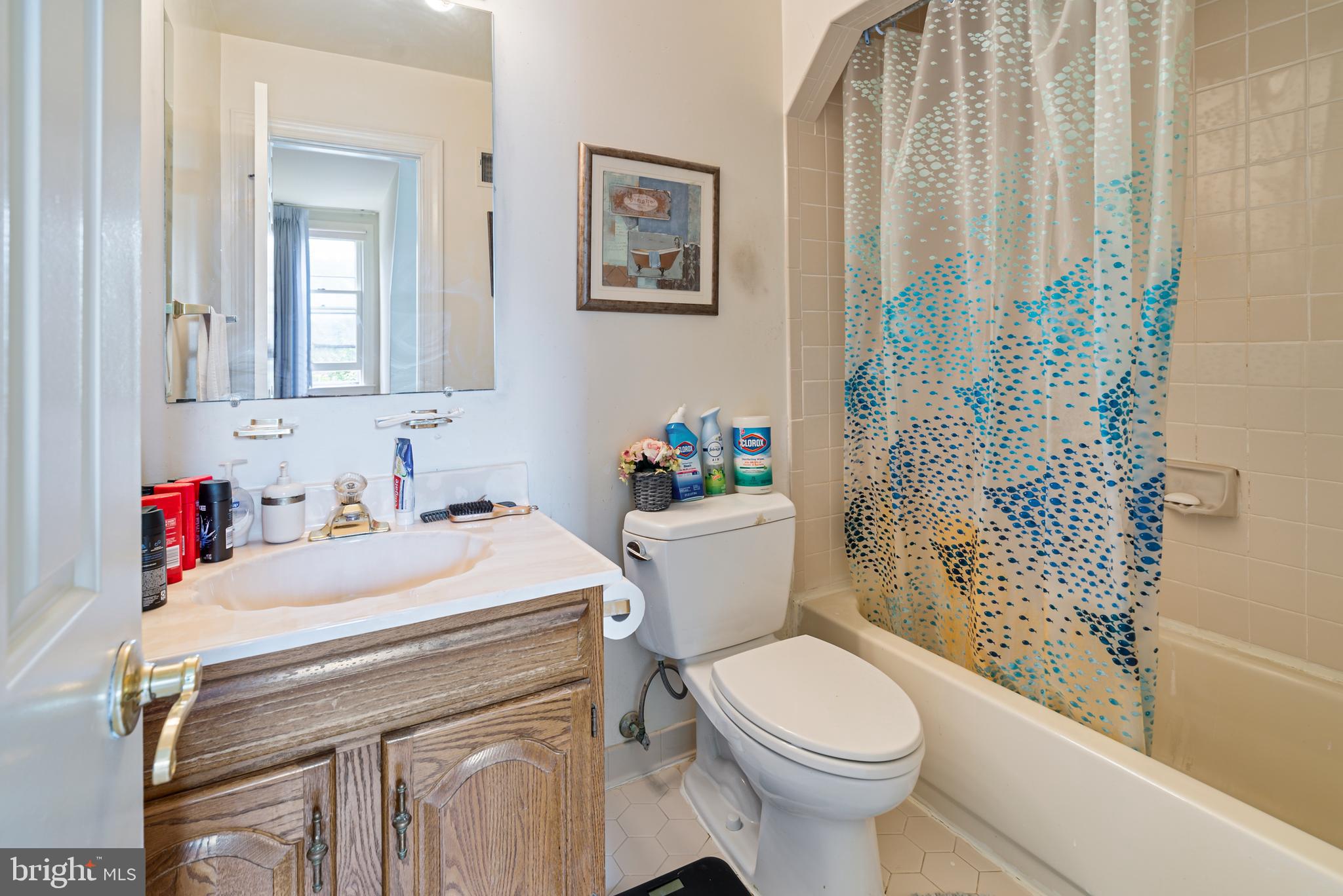 15008 Notley Road Silver Spring, MD 20905 - Photo 27 of 48 a bathroom with a sink a toilet and a shower curtain