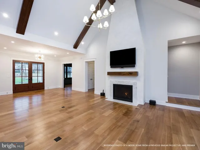 a view of an empty room with wooden floor fireplace and a window