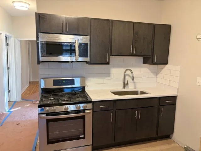 a kitchen with wooden cabinets and stainless steel appliances